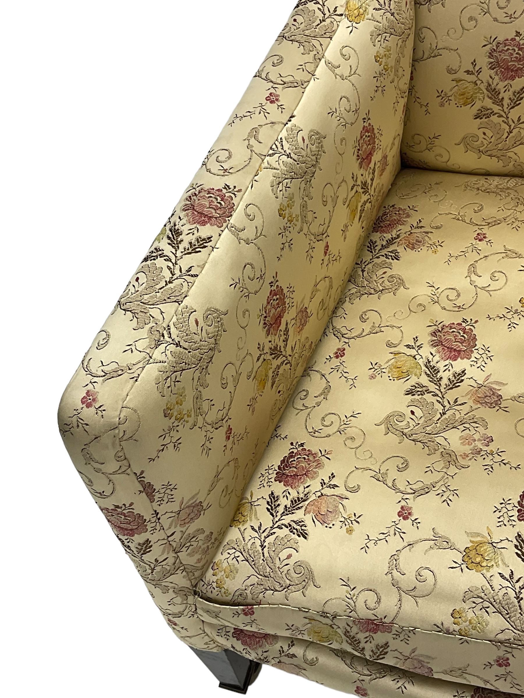 Edwardian hardwood-framed armchair, upholstered in floral pattern fabric, on square tapering front supports, brass and ceramic castors 