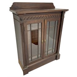 19th century mahogany display cabinet, rectangular top over frieze decorated with Vitruvian scroll mount, enclosed by two astragal glazed doors, the upright rails decorated with trailing bellflowers, on moulded plinth