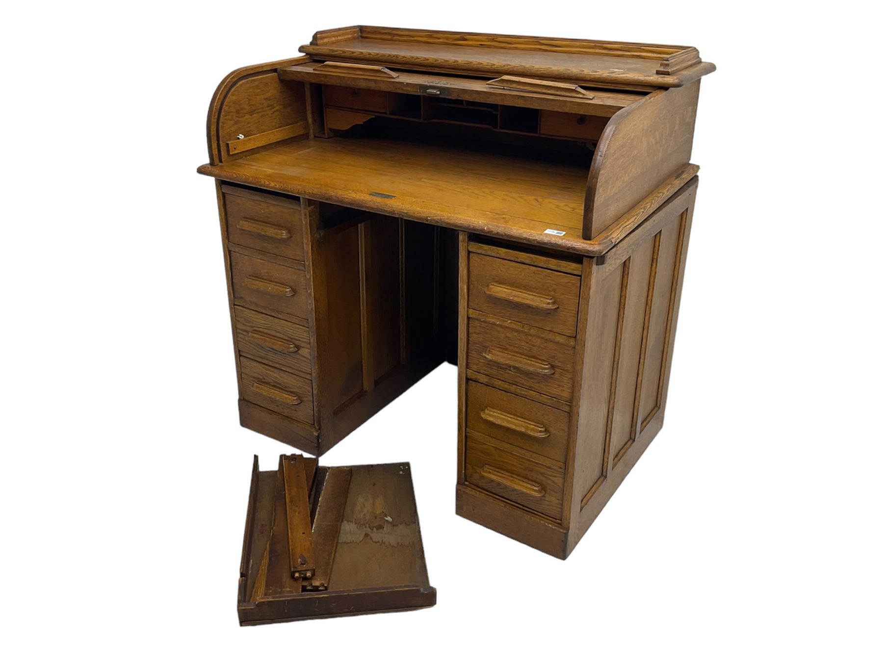 Early 20th century oak twin pedestal desk, tambour roll top enclosing fitted interior, eight drawers, on plinth base