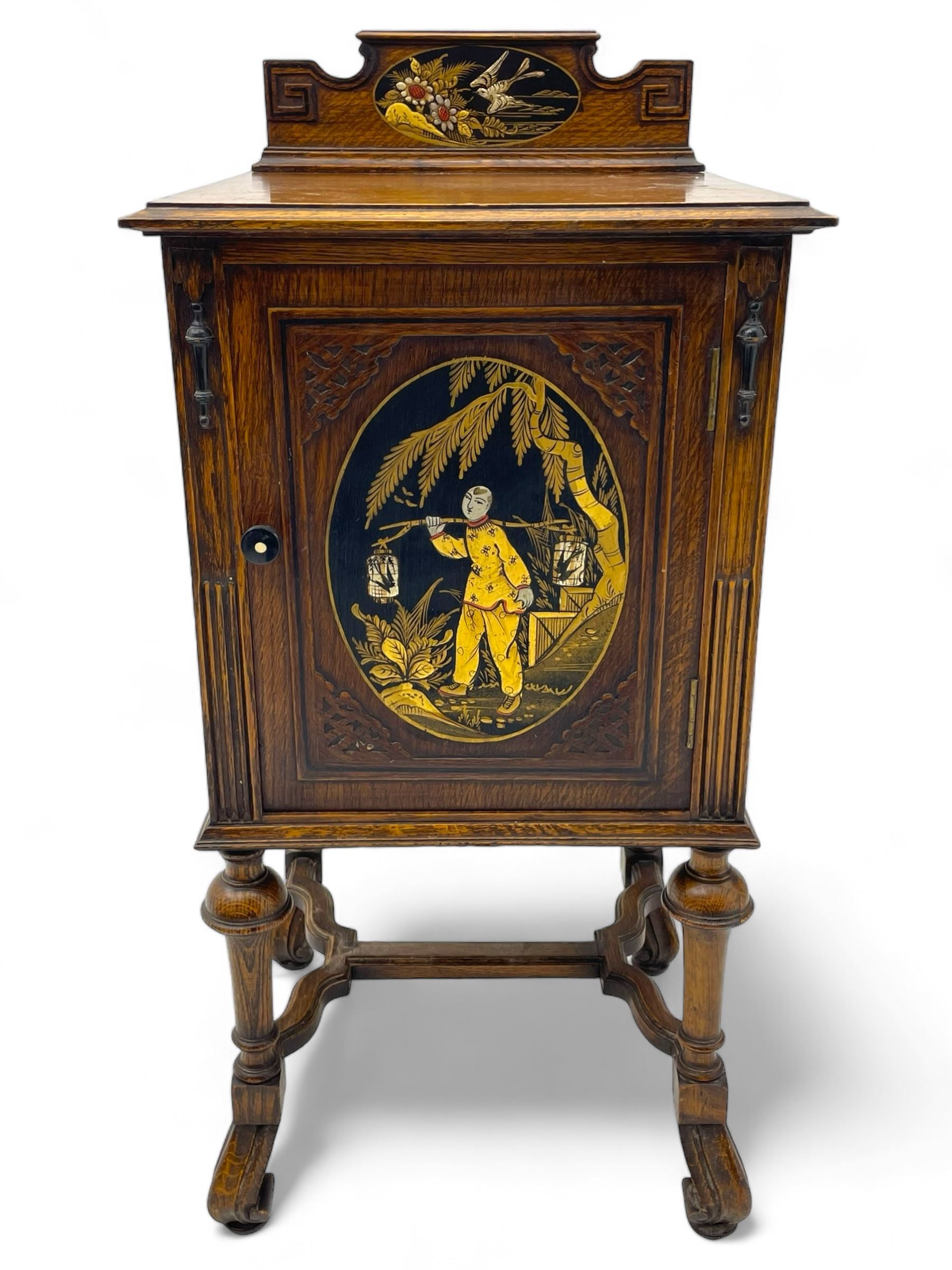 Early 20th century circa. 1920s oak bedside cupboard, raised back decorated with chinoiserie lacquer work depicting bird and flowers, moulded top over single door decorated with figure carrying bird cages, on turned supports united by shaped moulded stretchers, scroll carved feet