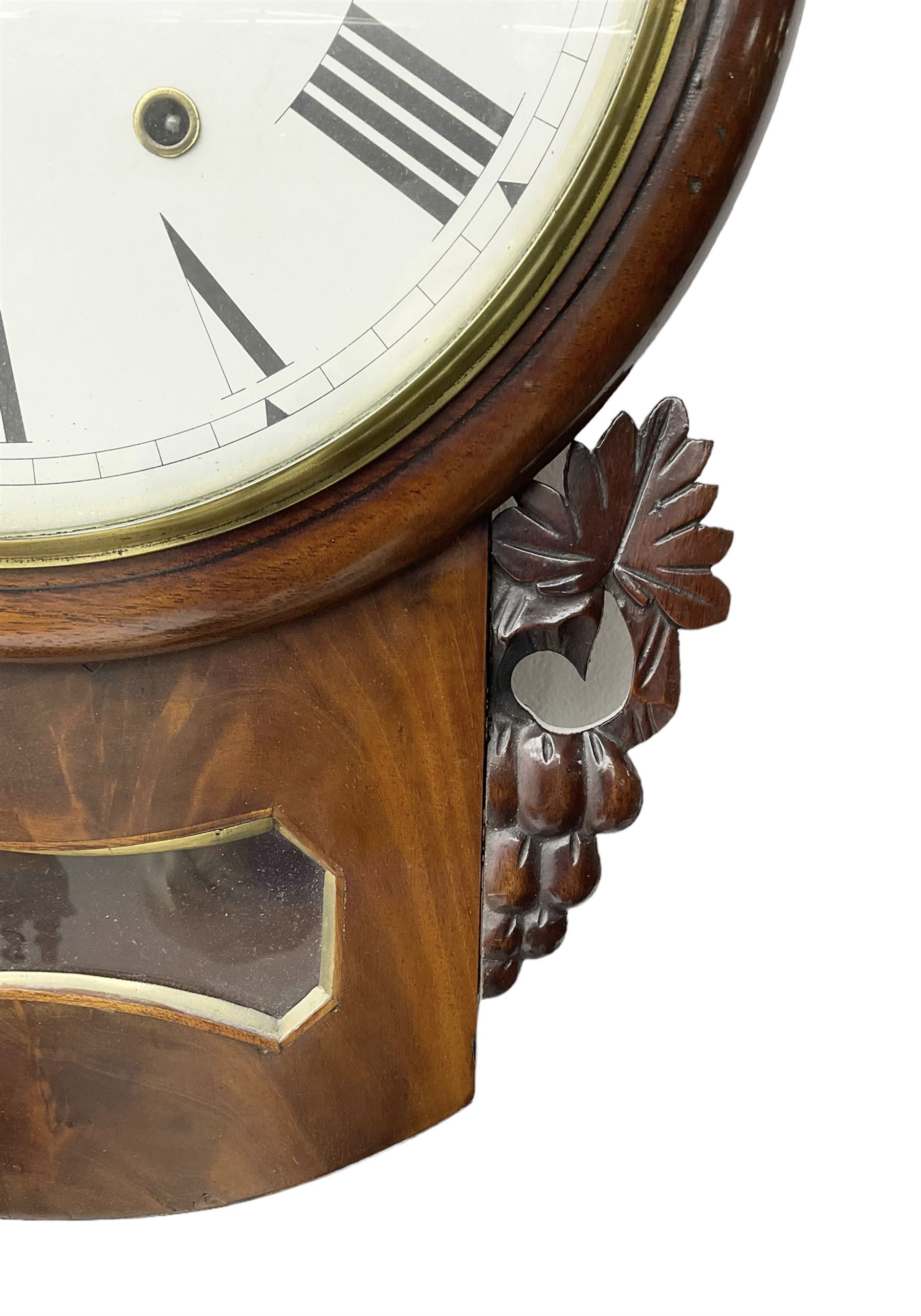 Late 19th century 8-day  drop dial wall clock in a mahogany case, carved ear pieces and glazed pendulum viewing glass, 12” painted dial with Roman numerals and Maltese steel hands, twin train going barrel movement striking the hours on a bell. No pendulum or key.