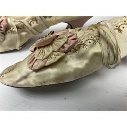 Pair of 19th century ivory silk satin ladies shoes, with rosette to the vamp, with pink silk satin heel, L23cm