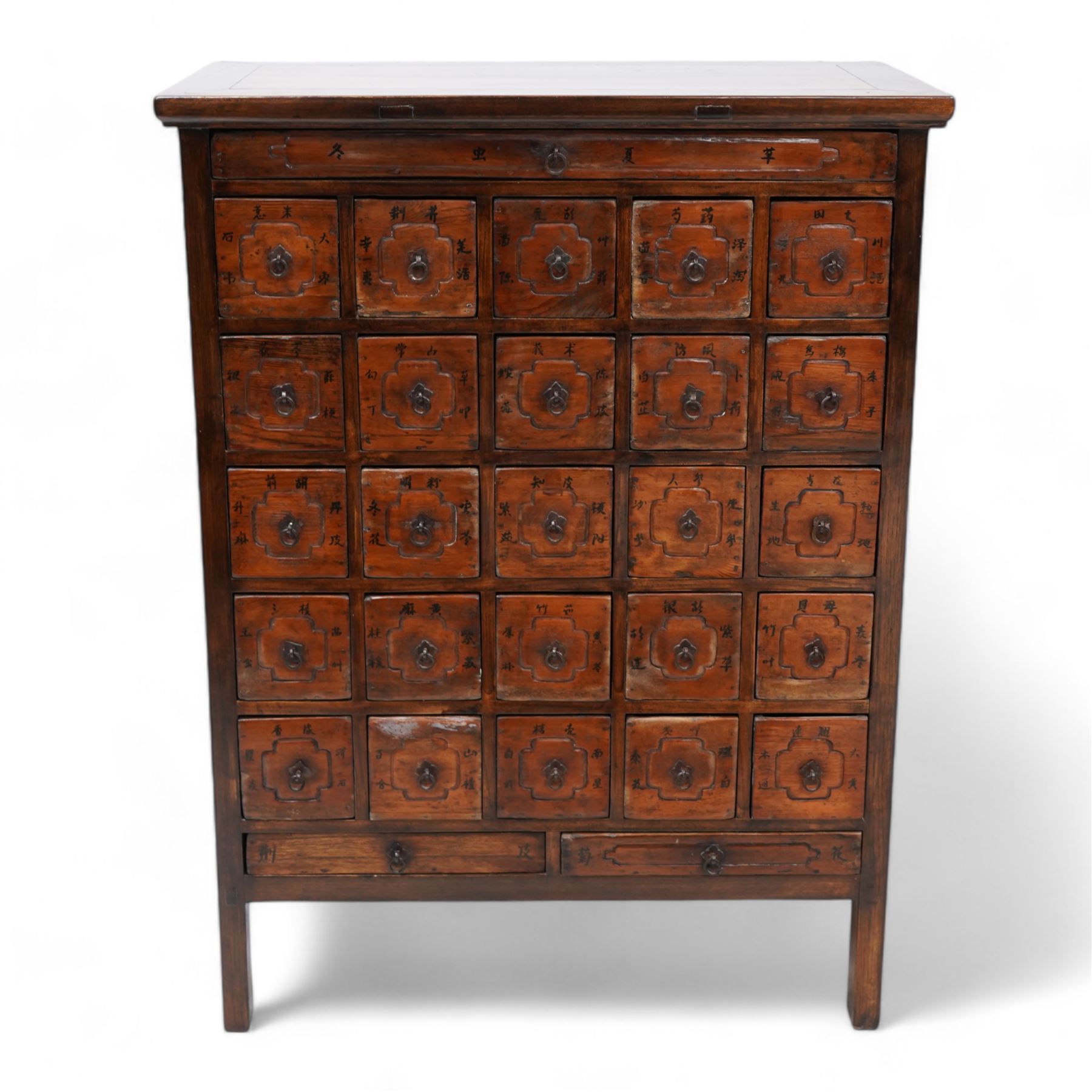 Early 20th century Chinese lacquered elm storage or spice chest, rectangular top with moulded edge, fitted with an assortment of twenty-eight drawers with wrought metal fittings, the facias etched with faux panels and painted with Chinese characters primarily relating to various spices and herbs, on stile feet