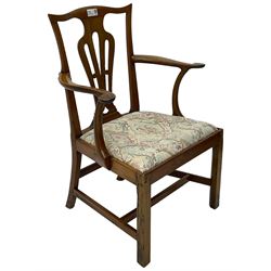 George III walnut elbow chair, shaped cresting rail over shaped pierced splat, the shaped arms with scroll carved terminals, upholstered drop in seat, on square chamfered supports united by plain stretchers 