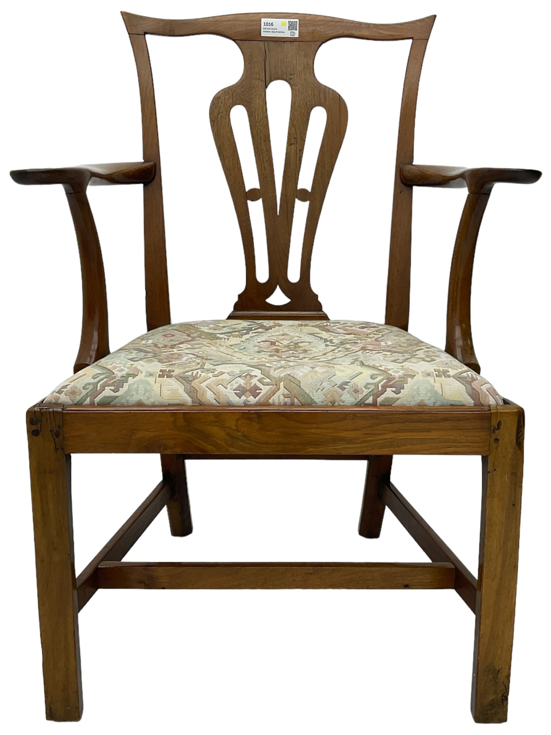 George III walnut elbow chair, shaped cresting rail over shaped pierced splat, the shaped arms with scroll carved terminals, upholstered drop in seat, on square chamfered supports united by plain stretchers 