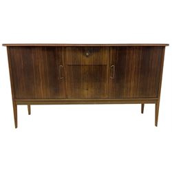 Mid 20th century teak sideboard, rectangular top with rounded corners over three central drawers, flanked by two cupboard doors enclosing shelves, raised on tapered supports