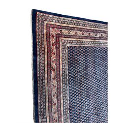 Large North-West Persian Arrak indigo ground carpet, the field decorated all-over with small Boteh motifs, multiple band border decorated with repeating geometric designs