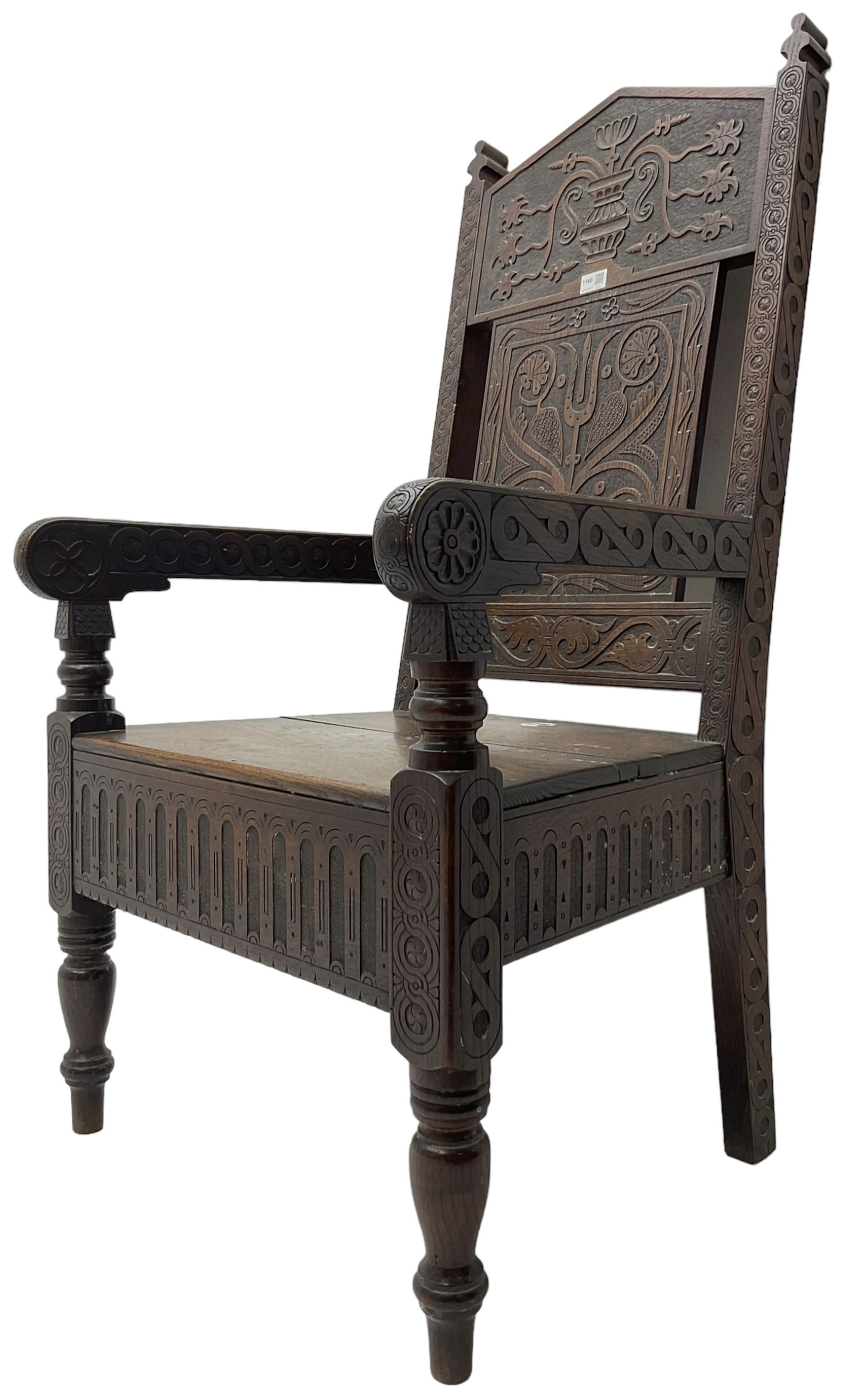 17th century design oak wainscot chair, the back profusely carved with scrolling foliate motifs, the arms carved with repeating guilloche decoration over an arcade apron and turned supports