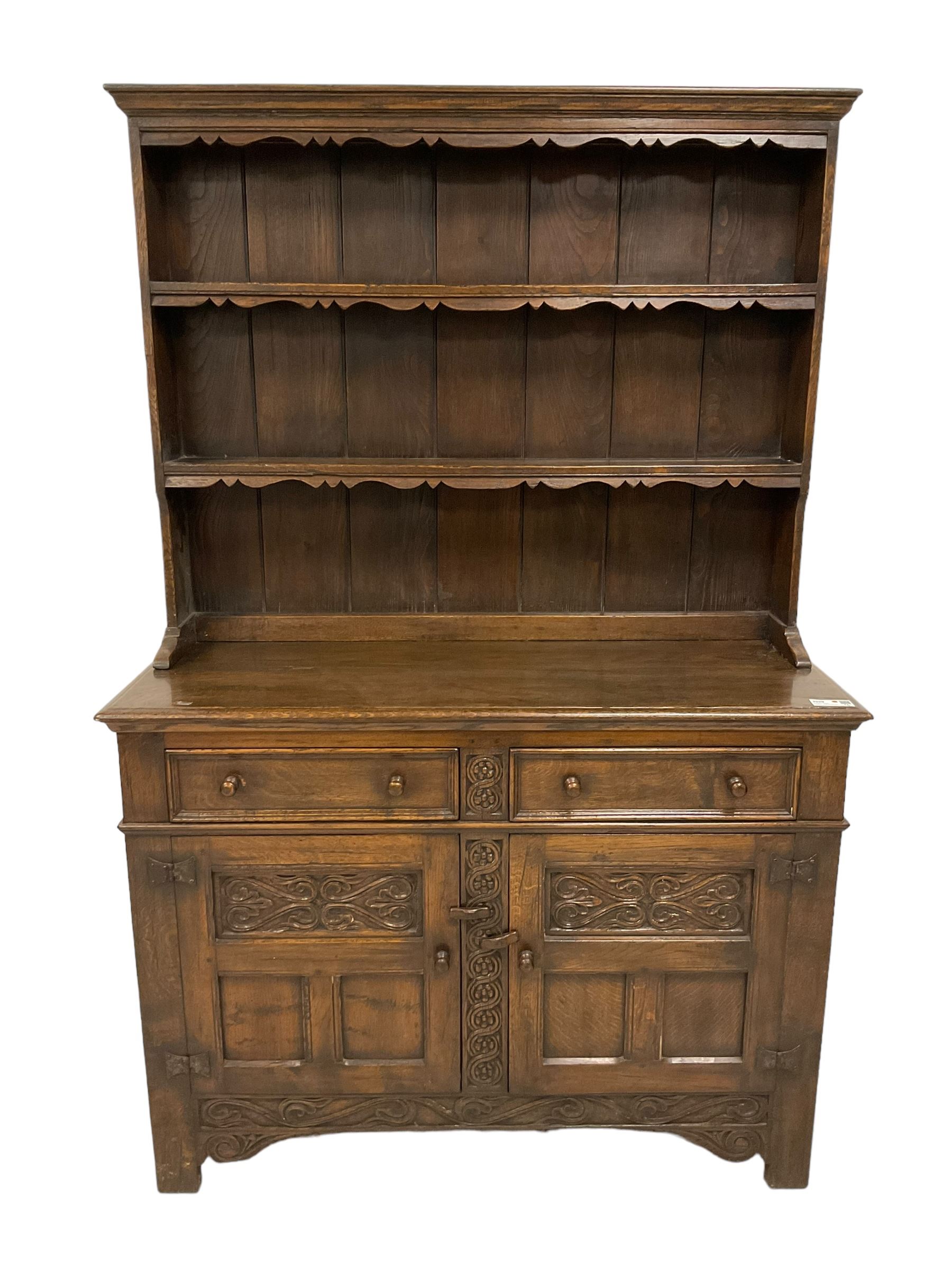 Georgian design oak dresser, two-tier plate rack with shaped aprons, the base fitted with two fielded moulded drawers, over two panelled cupboards carved with scrolling acanthus leaves, with guilloche carved central upright, on stile feet