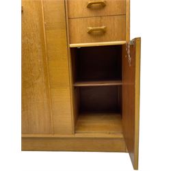 G-Plan - mid 20th century teak tallboy or combination wardrobe, left side with full-height hanging cupboard, right side with three drawers, the top fitted with vanity mirror, above cupboard with shelves, raised on a plinth base