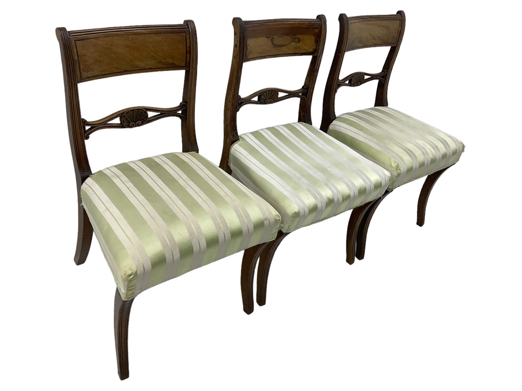 Set of six early 19th century mahogany dining chairs, bar cresting rail over pierced and shell carved middle rail, reed moulded uprights, upholstered seats on reed moulded sabre supports 