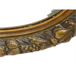 20th century giltwood and gesso oval wall mirror, the frame decorated with moulded fruit and foliage, bevelled mirror plate 