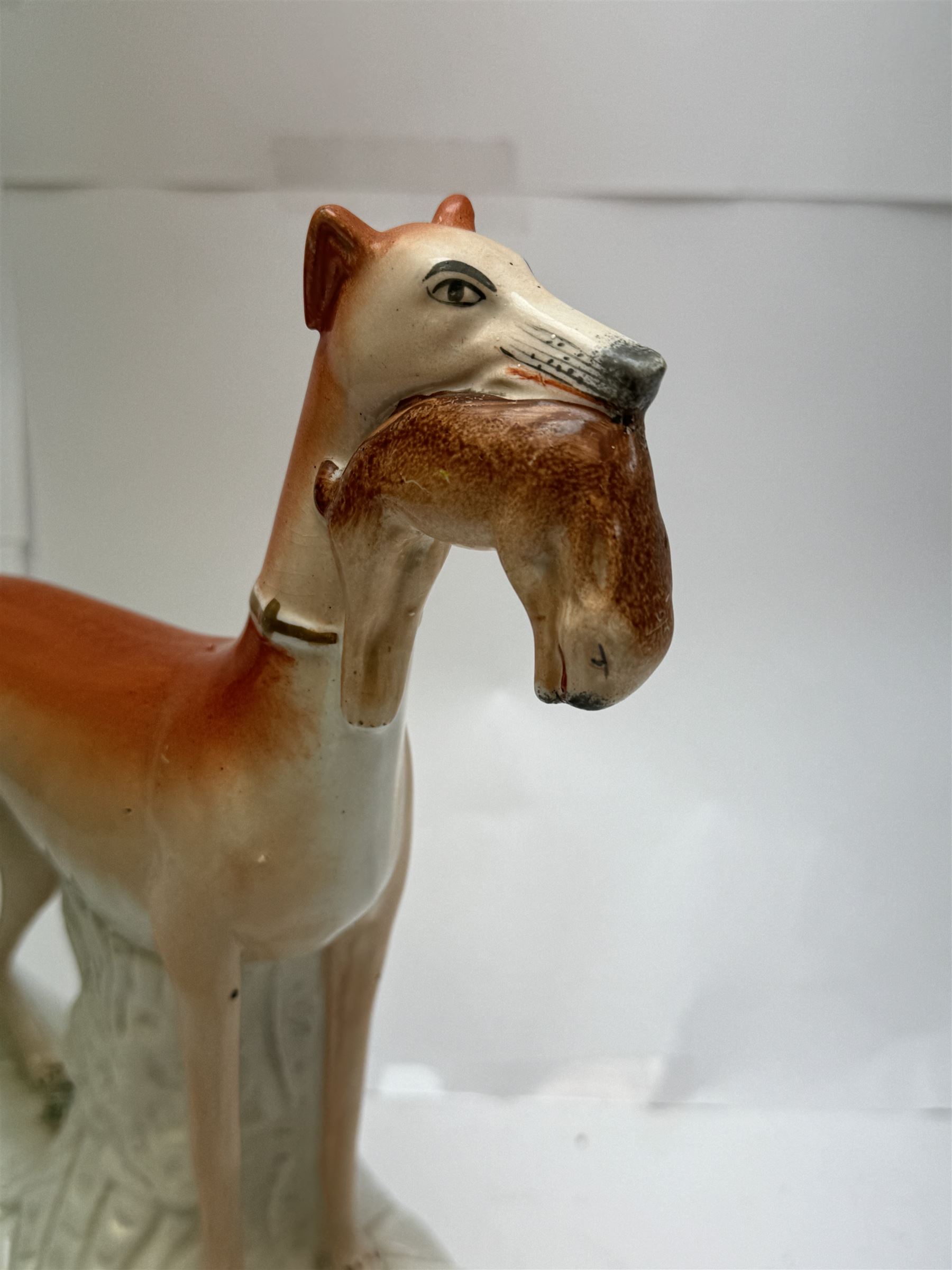 Pair of standing Staffordshire whippets with rabbits in their mouths, together with a pair of Staffordshire spaniels, whippets H30cm