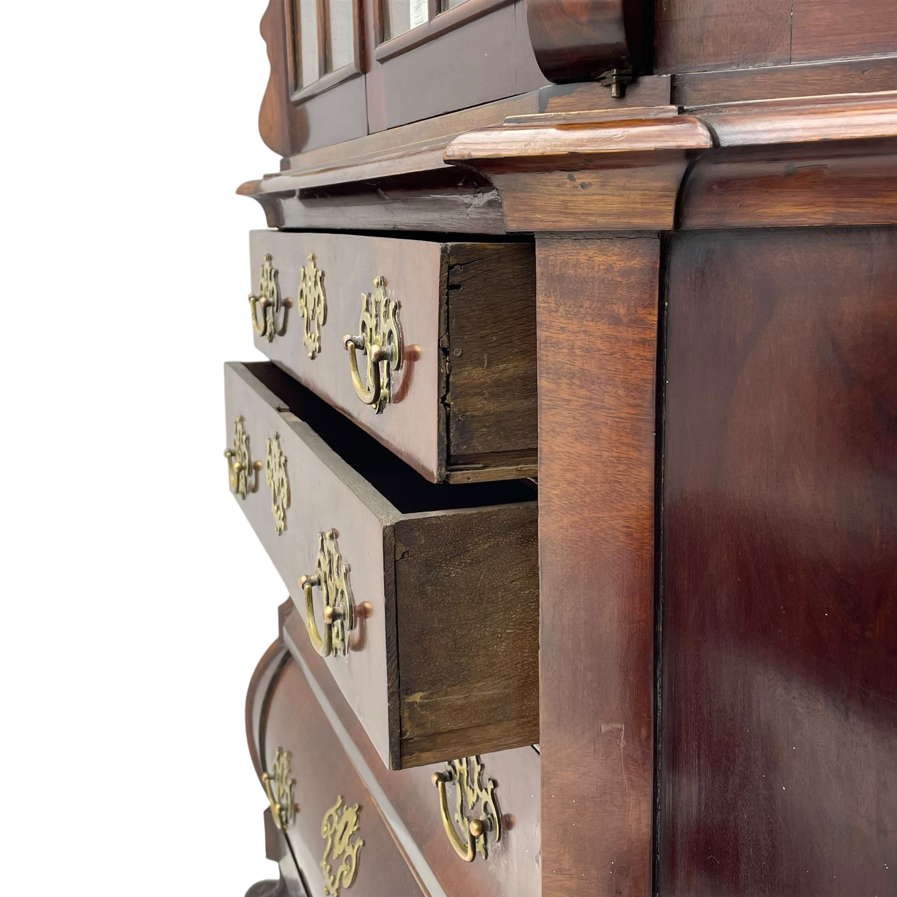 19th century Dutch mahogany vitrine on chest, shaped moulded pediment with central C-scroll and flowerhead carved mount, enclosed by two astragal glazed doors, the interior fitted with fabric lined shelves, four graduating long drawers below, on ball and claw carved feet 