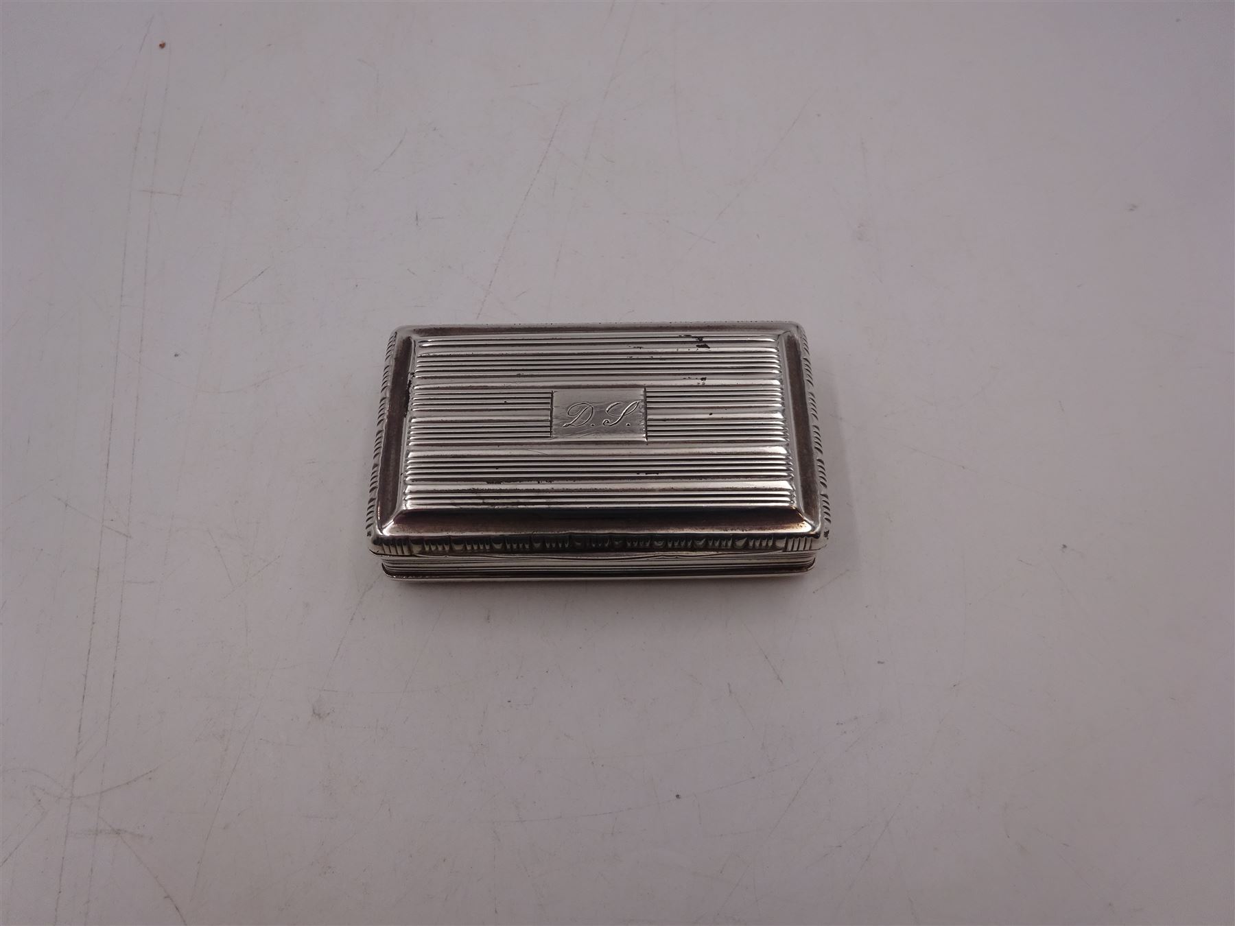 George III silver snuff box, of rectangular form, with banded decoration throughout and engraved cartouche to hinged cover, hallmarked John Shaw, Birmingham 1813, W7cm