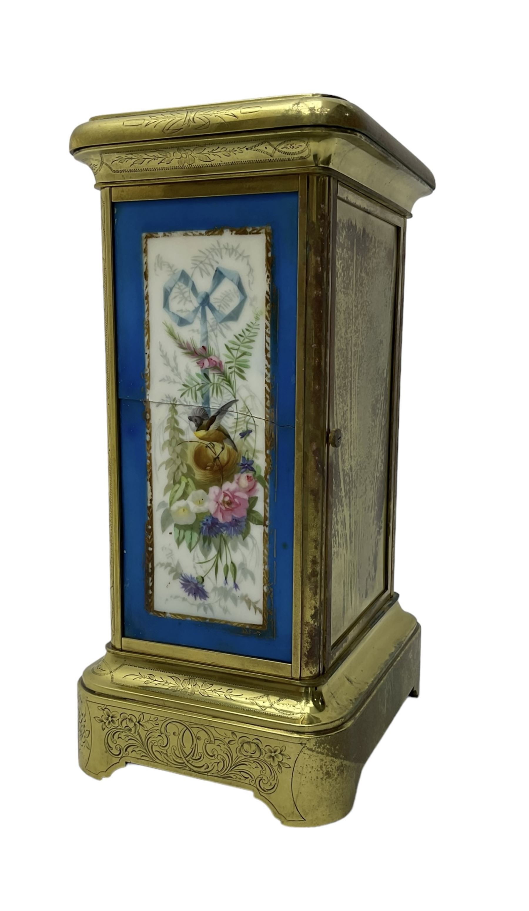 French - late 19th century 8-day mantle clock in an engraved brass corniche case with three rectangular porcelain panels decorated in the romantic Sevres style, dial with brass hands, cartouche Roman numerals and a depiction of cupid to the dial centre, rack striking movement sounding the hours and half hours on a bell. With pendulum.