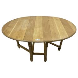 Contemporary oak and beech dining table, oval drop-leaf top on turned supports united by stretchers, gate-leg action base