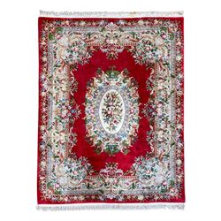 Chinese crimson ground washed woollen carpet decorated with floral medallion and border 