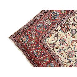 Persian Sarough ivory ground rug, the field decorated with curled leafy branches and palmettes, crimson ground border decorated with further palmettes and floral sprays, within guard stripes 