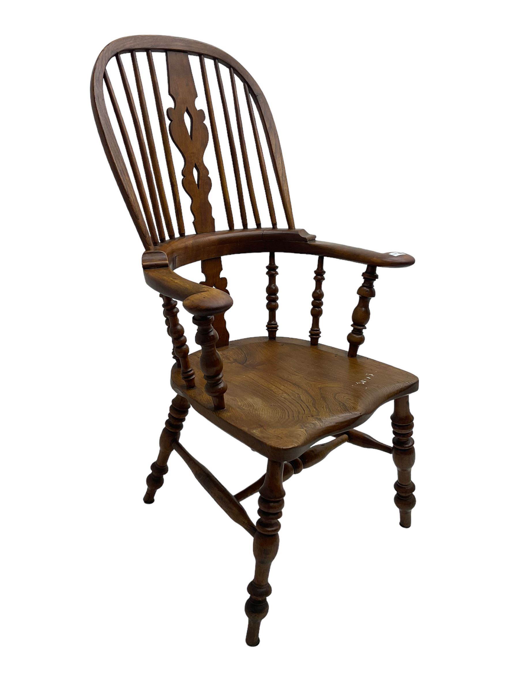 Elm and beech high back Windsor chair,  high hoop back with pierced splat and spindle supports over shaped saddle seat, raised on ring turned supports united by H-stretcher