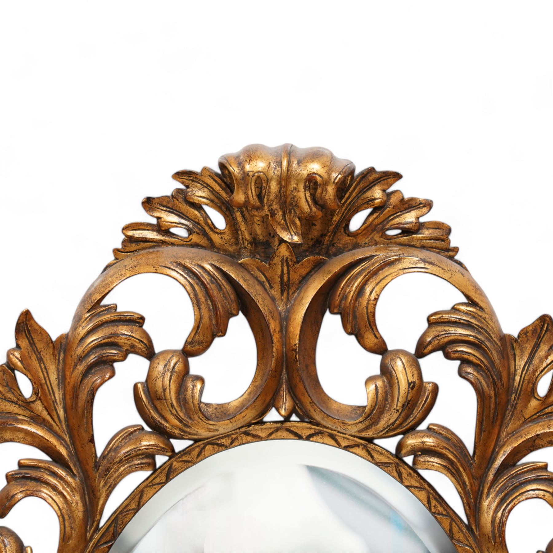 Florentine design gilt wall mirror, bevelled oval mirror plate surrounded by scrolling and interlaced acanthus leaves, curled leaf pediment 