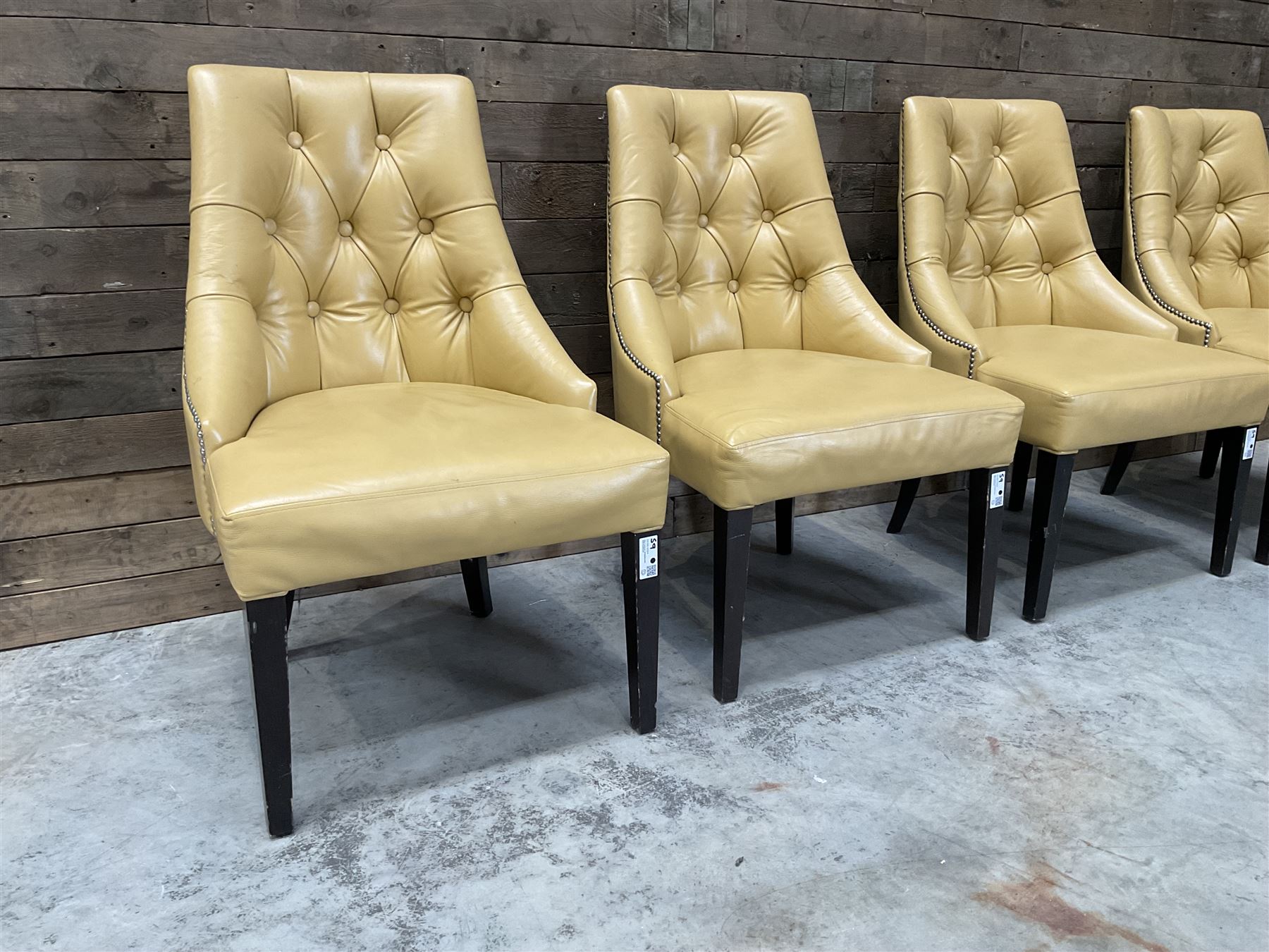 Four high back chairs upholstered in buttoned beige leather, studded detail, rosewood legs