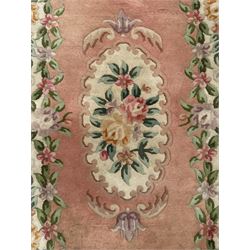 Chinese Aubusson design pink ground rug, the field decorated with an oval medallion filled with floral motifs in pastel shade, surrounded by floral garlands and foliate scrolls