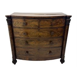 Early Victorian mahogany bow front chest, two short over three long graduating cockbeaded drawers, flanked by faceted columns with carved acanthus leaf capitals, standing on turned bun supports with fluted detailing