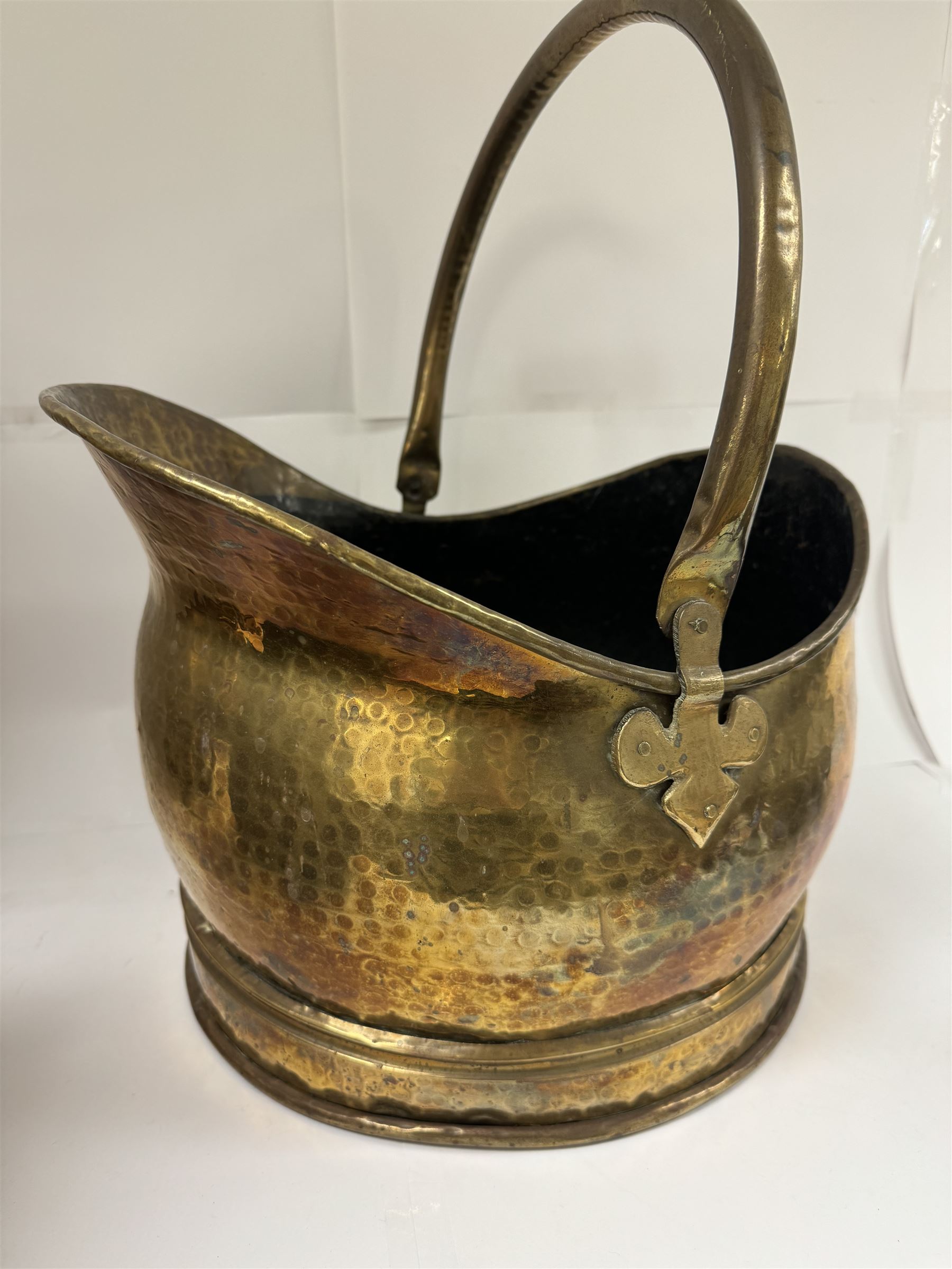 Middle eastern copper bucket, with chased and embossed band of animal decoration, together with a copper jardinière embossed with floral panels, copper plate with embossed leaf motif and two brass helmet shaped coal scuttles, bucket H26cm