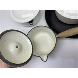 Set of five white Le Creuset pans of graduating size together with matching frying pan and orange twin handled dish