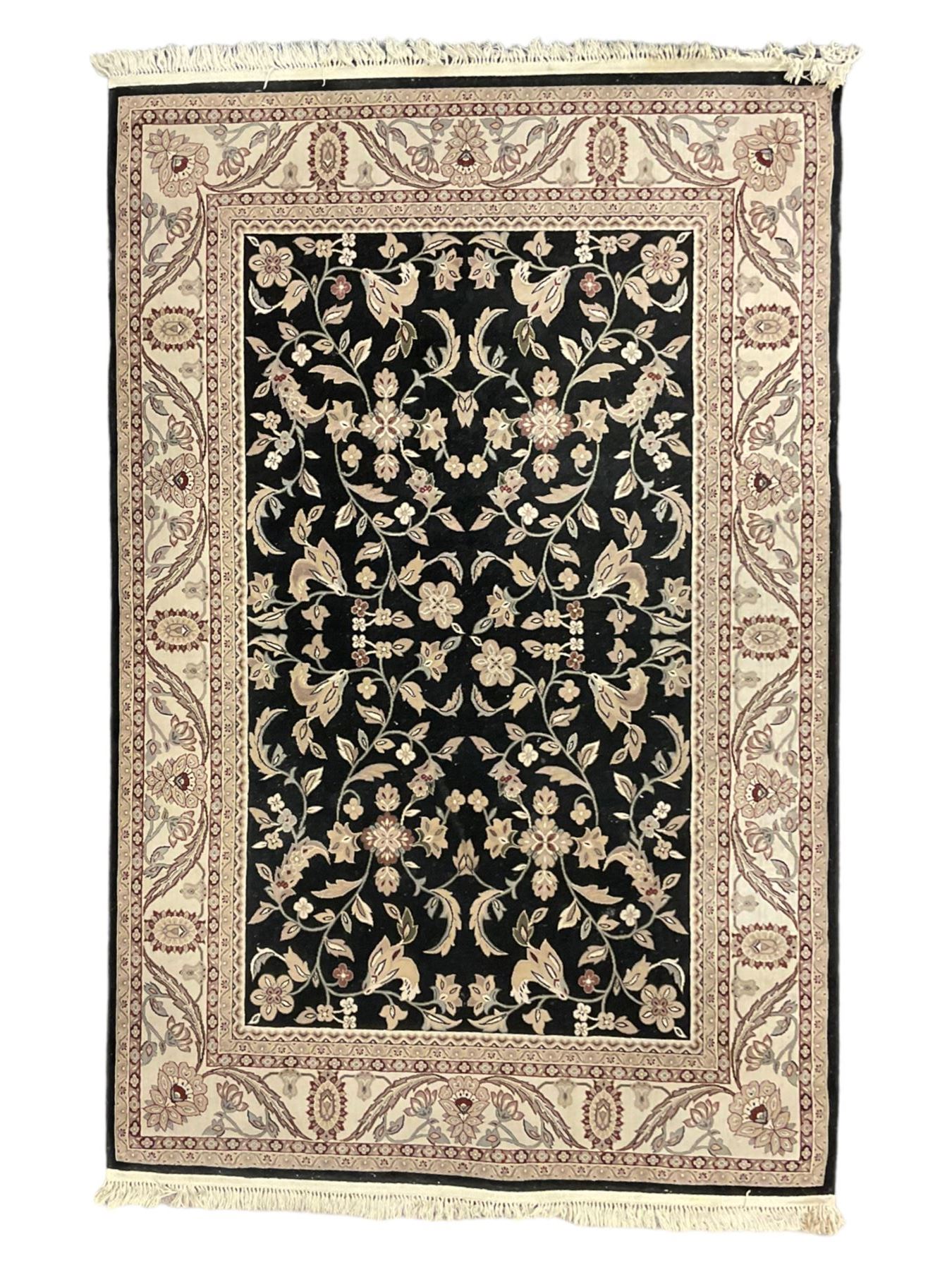 Persian design dark indigo ground rug, the field decorated with trailing branches and foliate motifs, repeating scrolling border with stylised plant motifs