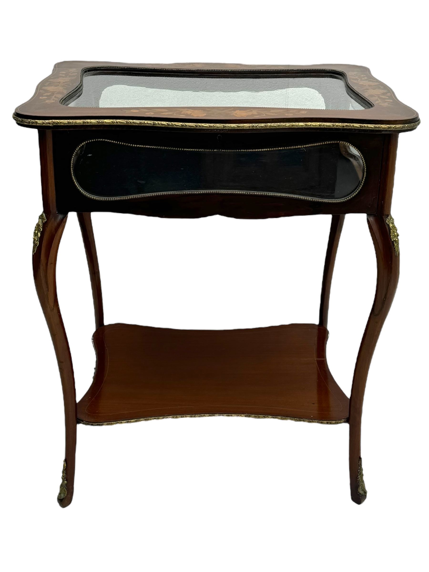 Late 19th century inlaid mahogany bijouterie table, glazed hinged top with floral marquetry, enclosing a felt-lined interior, lower shelf, ormolu mounts on cabriole supports with gilt accents