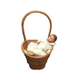 Pull along wicker basket with wicker handle, composite jointed doll and a collection of linen