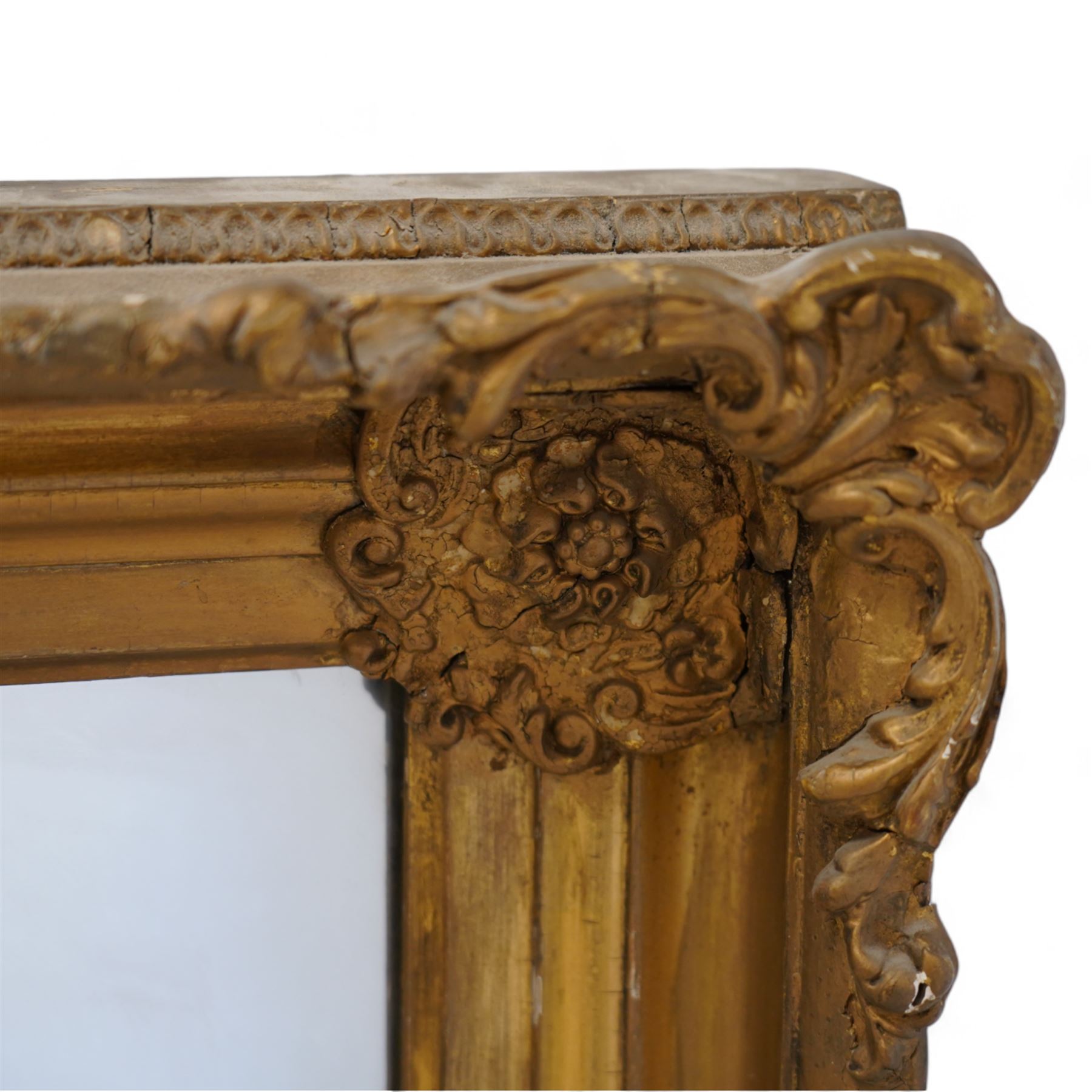 19th century gilt wood and gesso framed wall mirror, moulded rectangular swept frame, each corner decorated with floral cartouche and extending foliage, plain mirror plate 