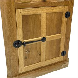 Mouseman - oak floor standing corner cupboard, fall front compartment over single panelled door, with wrought metal loop handle and latch, on moulded plinth base, carved in relief with mouse signature, by the workshop of Robert Thompson, Kilburn 