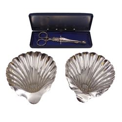 Pair of late Victorian silver shell butter dishes, upon three bun feet, hallmarked James Deakin & Sons, Sheffield 1900, together with a pair of late Victorian scissor action sugar nips, engraved with foliate decoration, hallmarked Sheffield 1897, maker's mark indistinct