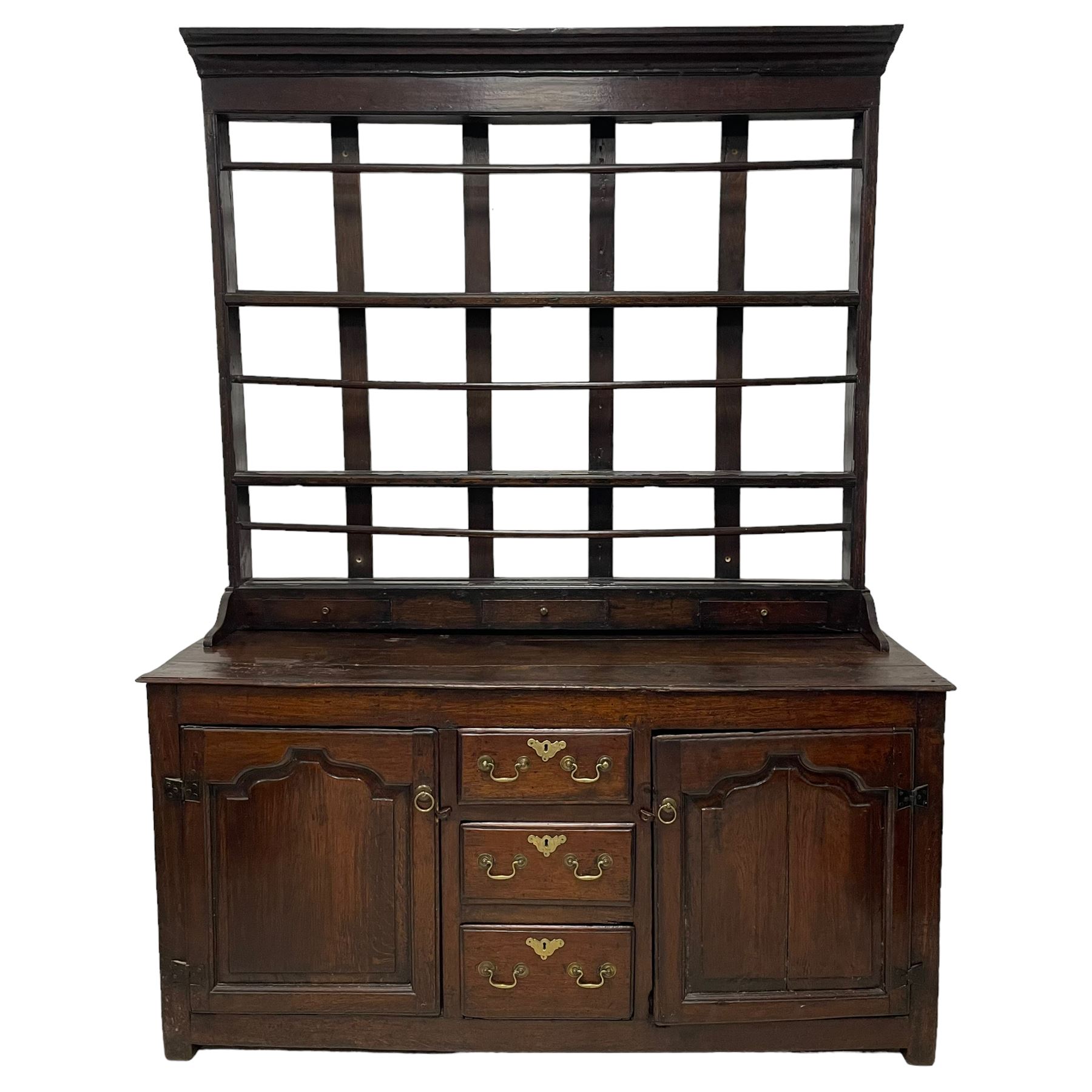 18th century oak dresser, projecting cornice over three heights plate rack with three small drawers, rectangular ovolo-moulded top over three central drawers and two flanking cupboards, enclosed by fielded panelled doors, on stile supports 