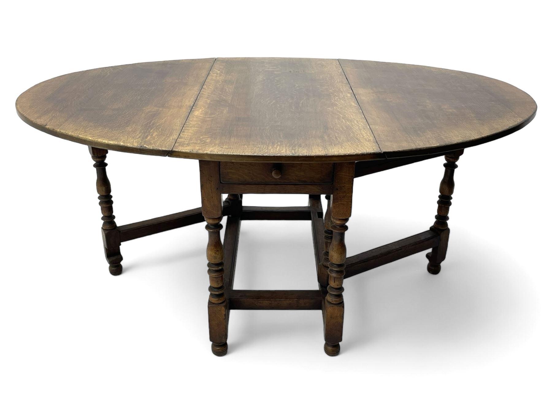 18th century oak dining table, oval drop-leaf top on gate-leg action base, turned supports united by turned stretchers, fitted with single end drawer