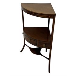 George III mahogany two-tier corner washstand, the inlaid top with geometric border, central drawer flanked by two faux drawers each with brass pull handle, on splayed supports united by shaped under-tier