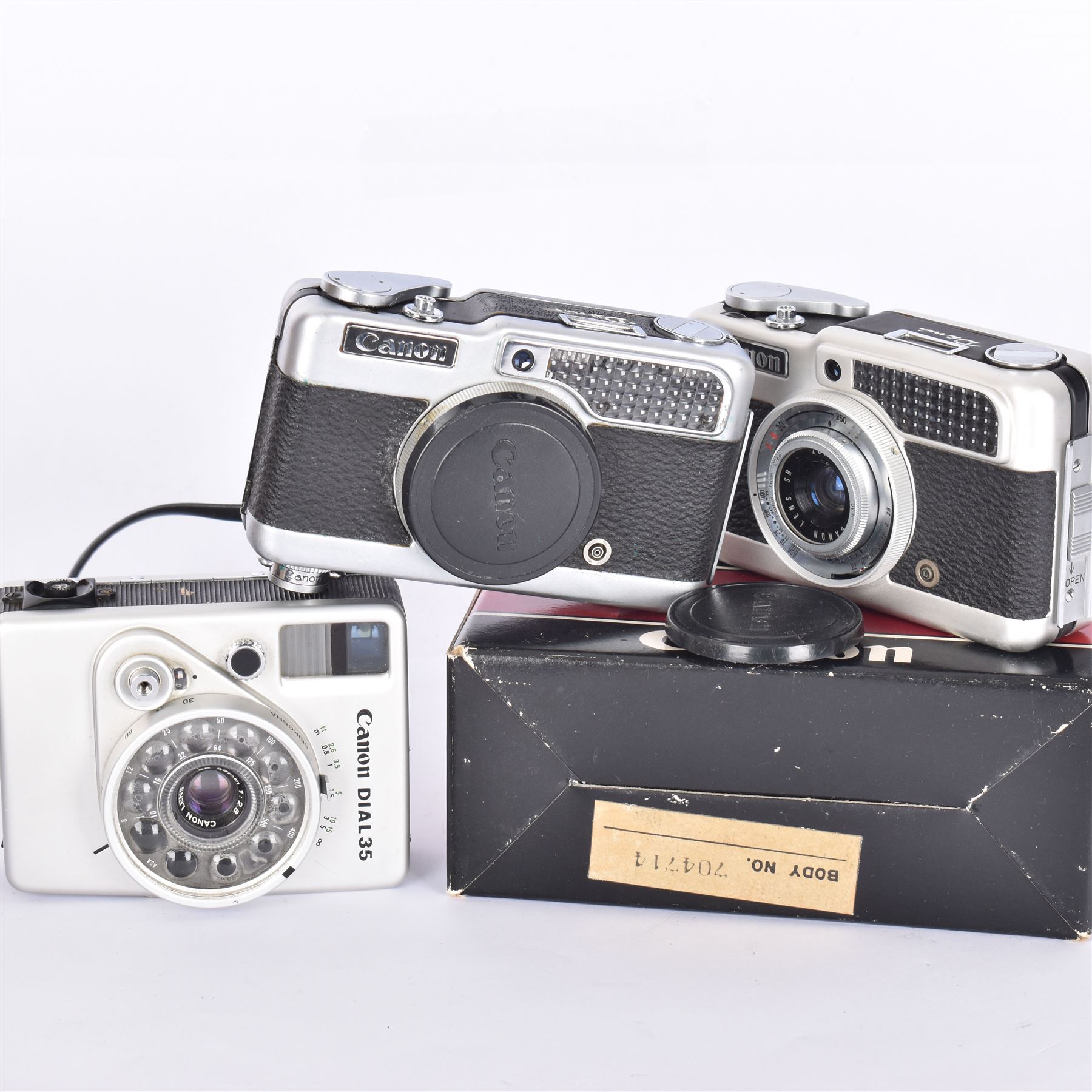 Three Canon half frame cameras, comprising two Canon Demi examples, serial nos. 243090 & 704714, one example boxed, and a Canon Dial35 serial no. 341572