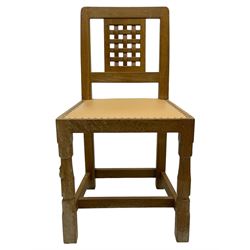 Mouseman - set of six oak dining chairs, pierced and carved lattice panel back over tan leather seat with studded band, on octagonal front supports united by plain H stretchers, carved with mouse signature, by the workshop of Robert Thompson, Kilburn 