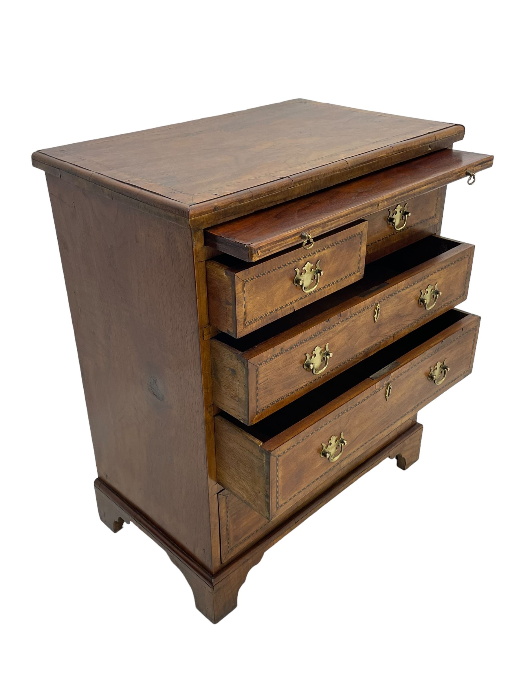 Small Georgian design walnut chest, moulded rectangular top with book-matched veneer enclosed by checkered stringing and crossbanding, brushing slide over two short and three long drawer, on bracket feet