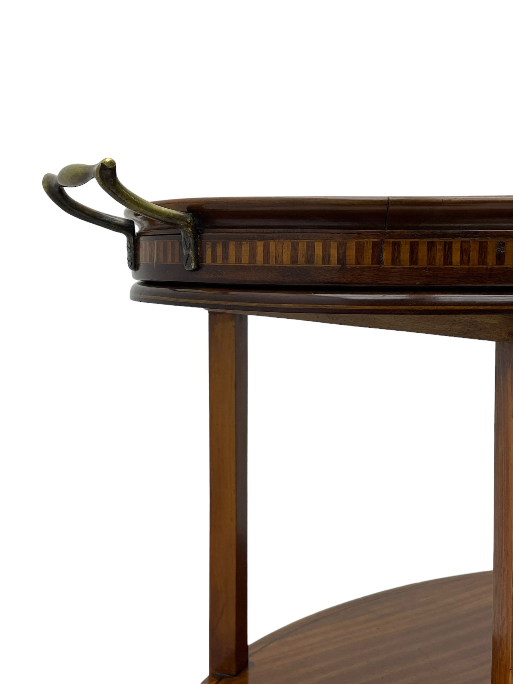 Edwardian satinwood tray top stand of oval form, tray top with glazed base and brass handles over two tiers, each with checkered inlaid band, on square tapering and splayed supports