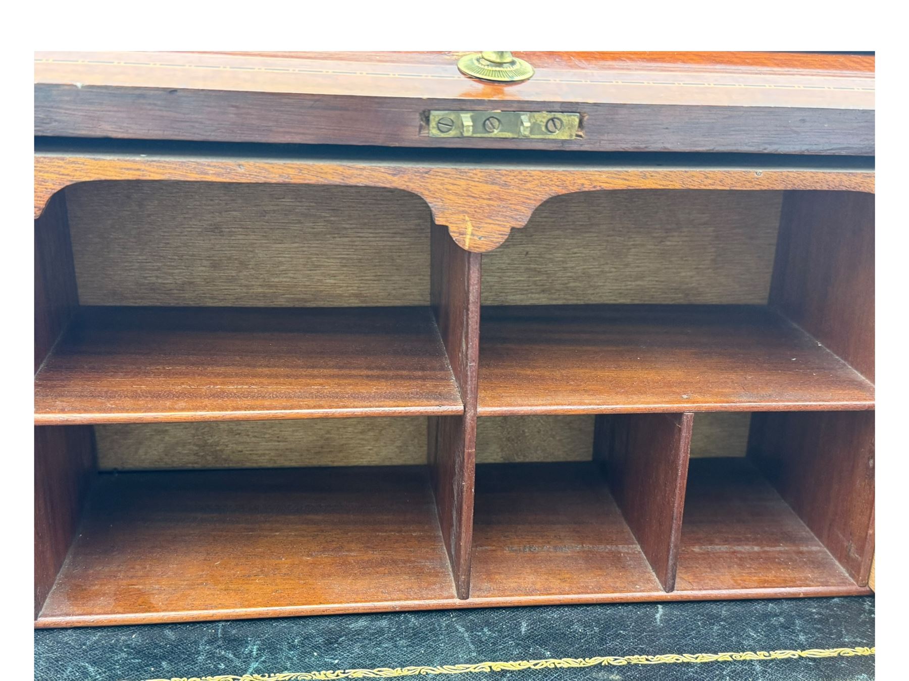 Edwardian inlaid mahogany roll-top desk, cylindrical lid enclosing fitted interior with pigeonholes, drawers and retractable writing surface, over two drawers with brass pull handles, on tapered supports with brass and ceramic castors