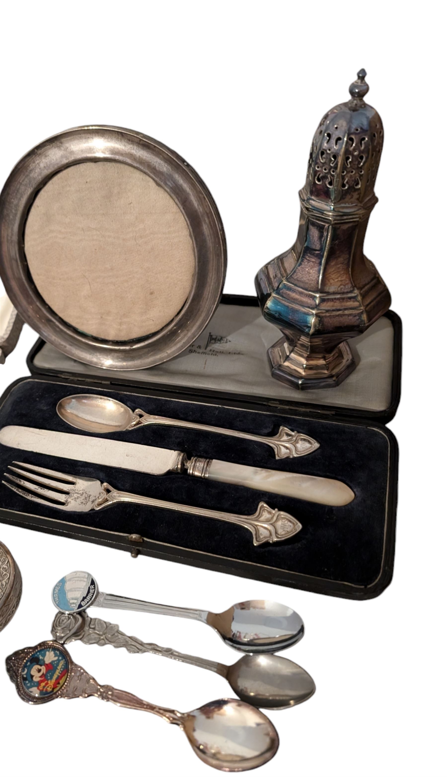 Silver photograph frame and a silver mustard spoon, both hallmarked, together with an Egyptian silver box, silver plated Walker & Hall christening set, silver plated sugar caster, silver plated coffee bean spoons, and silver plated pepper and salt shaker