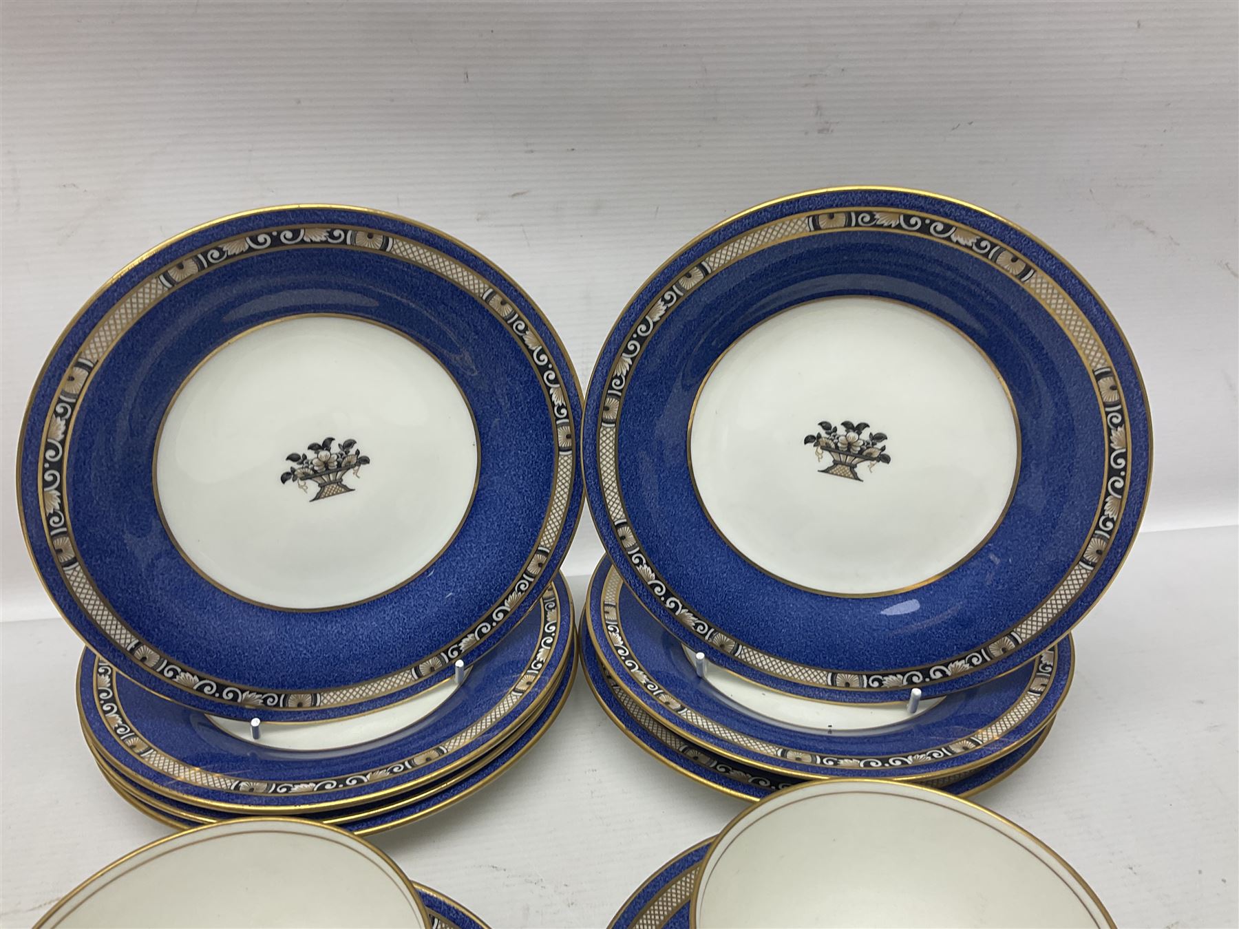 Wedgwood part tea and coffee service, comprising coffee pot, six coffee cans with five saucers, seven teacups with ten saucers and seven side plates, each decorated with floral bouquet to centre, in a gilt and speckled blue border, pattern x9933, with printed mark beneath