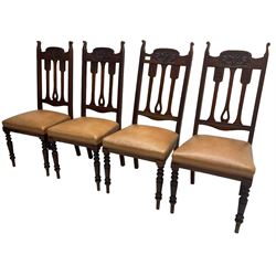 Set of four Edwardian walnut dining chairs, foliate carved high back over sprung seat upholstered in tan faux leather, raised on turned supports