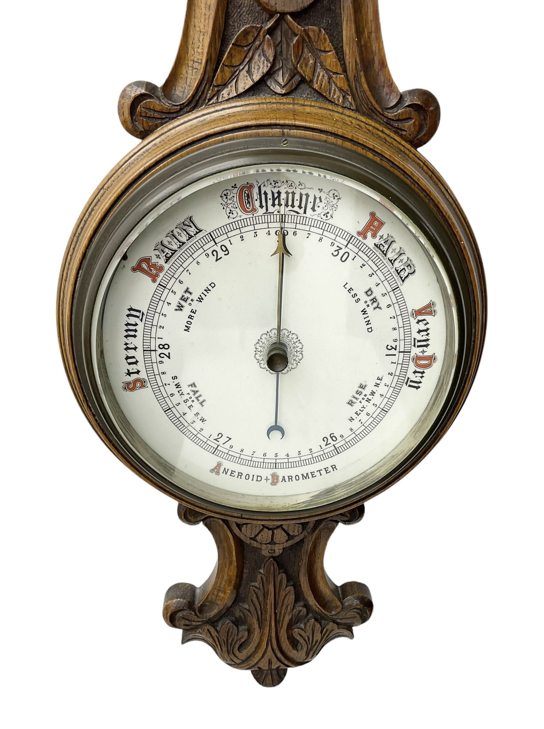 Edwardian - carved oak aneroid barometer, with a rounded top carved with scroll work, 8