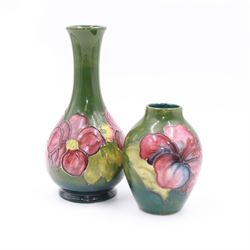 Two small Moorcroft vases decorated in the Anemone and Hibiscus on green grounds, with markers mark beneath, largest H16cm 