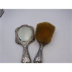 Art Nouveau silver mounted two piece dressing table set, comprising hair brush and hand mirror, each heavily embossed with naturlistic florals and engrved with monograms, hallmarked Walker & Hall, Sheffield 1907